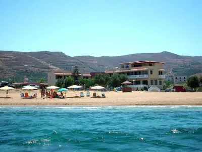 a beach with umbrellas and people on the beach at Gramvoussa Bay in Kissamos
