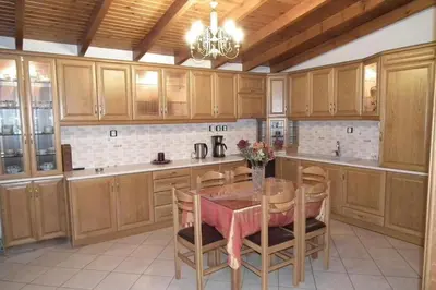 a kitchen with wooden cabinets and a table with chairs at Gramvoussa Bay in Kissamos