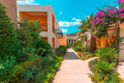 a walkway between two buildings with flowers at Oreia in Palaiochóra