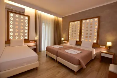 a hotel room with two beds and two windows at Hotel Aghas Paleochora in Palaiochóra