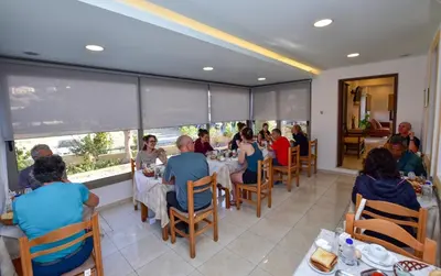 a group of people sitting at a table in a restaurant at Hotel Aghas Paleochora in Palaiochóra
