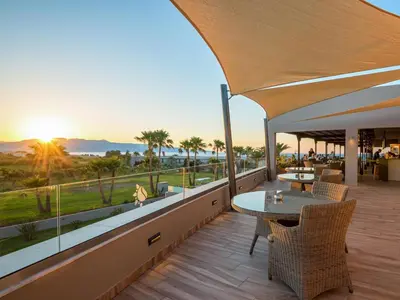 a patio with a table and chairs on a balcony at Solimar Aquamarine Resort in Gerani Chanion