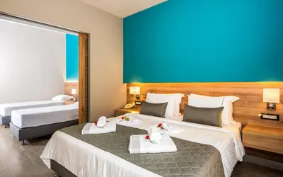 a hotel room with two beds with towels on them at Solimar Aquamarine Resort in Gerani Chanion