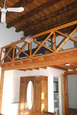 a room with a wooden ceiling with a chandelier at Oasis Guesthouse in Chania Town