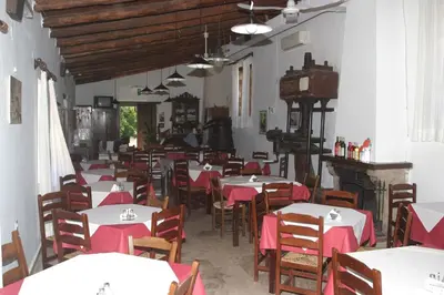 a restaurant with tables and chairs with red table cloth at Oasis Guesthouse in Chania Town