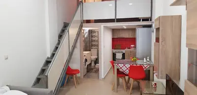 a small kitchen with a table and red chairs at Rodoula Luxury Αpartment 3 in Chania Town