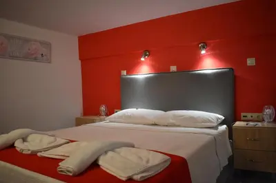 a bedroom with red walls and a bed with towels on it at Rodoula Luxury Αpartment 3 in Chania Town