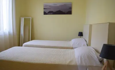 two twin beds in a bedroom with a picture on the wall at Central House with Quiet Garden in Kissamos