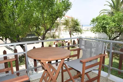 a wooden table and two chairs on a balcony at Central House with Quiet Garden in Kissamos