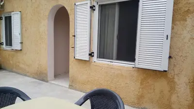 a building with two windows and a table and chairs at Sitzanaki Home in Chania Town
