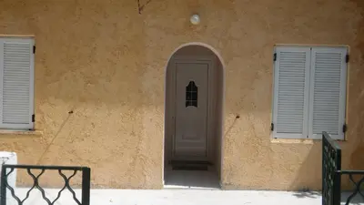 a door in the side of a building with two windows at Sitzanaki Home in Chania Town