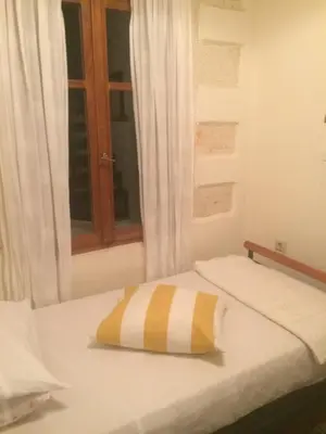 a bed with a yellow and white pillow on it at Rooms 47 in Chania Town