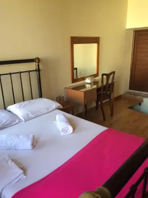 a bedroom with two beds and a desk with a mirror at Rooms 47 in Chania Town