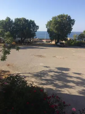 a parking lot with trees and the ocean in the background at Rooms 47 in Chania Town