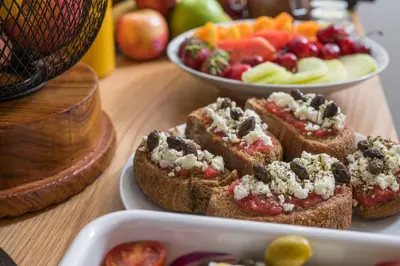 a plate of food with bread and fruit on a table at Casa D'Irene Deluxe Hotel in Falasarna
