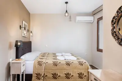 a bedroom with a bed with a table and a mirror at Lila hill house in Stalos