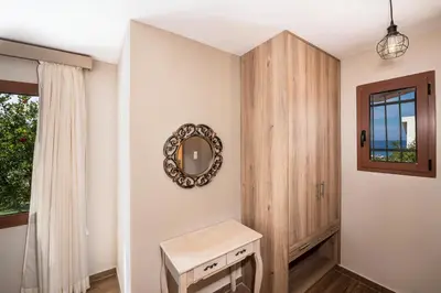 a dressing room with a mirror and a wooden cabinet at Lila hill house in Stalos
