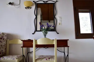 a room with a table and two chairs and a mirror at Marinakis Sea View Studios in Sougia