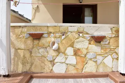 a stone wall with a shoe hanging on it at Marinakis Sea View Studios in Sougia