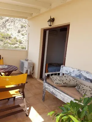 a room with a bed and a table and a window at Marinakis Sea View Studios in Sougia