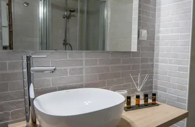 a bathroom with a white sink and a shower at Aelia Apartments in Chania Town