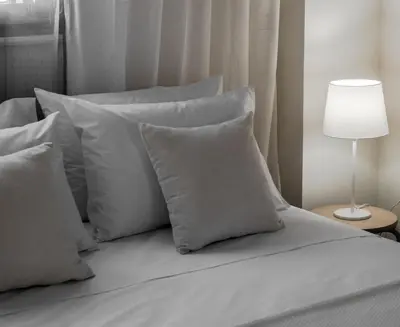 a bed with white pillows and a lamp on a table at Aelia Apartments in Chania Town