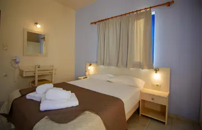 a bedroom with a bed with towels on it at Scorpios Family Rooms in Palaiochóra