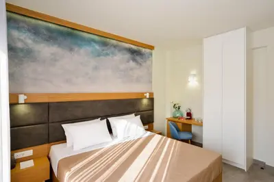 a bedroom with a bed with a painting on the wall at Elia Kalamaki Hotel in Kalamaki Chanion