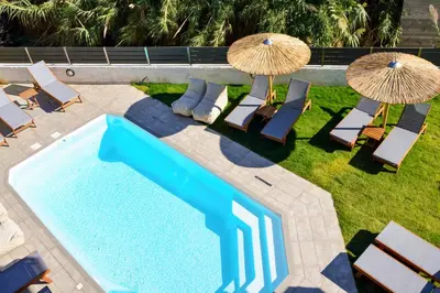 an overhead view of a pool with chairs and umbrellas at Elia Kalamaki Hotel in Kalamaki Chanion