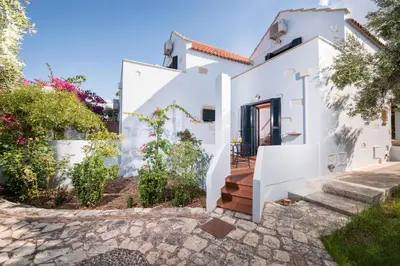 a white house with stairs and flowers at Orionas Village in Kato Daratso