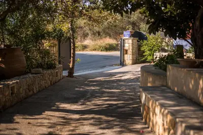 a sidewalk with a tree and a fence and a street at Orionas Village in Kato Daratso