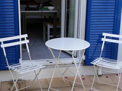 two chairs and a white table and chairs on a porch at Astra Hotel Apartments in Kato Daratso