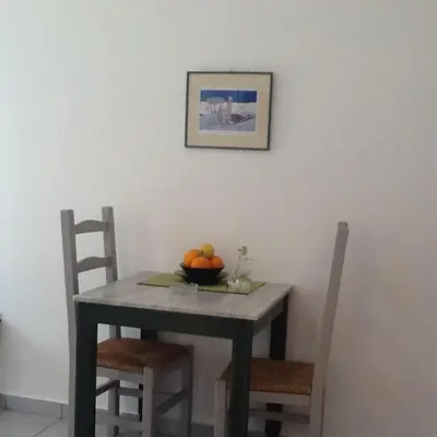 a dining room table with a bowl of fruit on it at Astra Hotel Apartments in Kato Daratso
