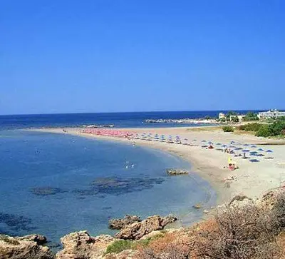 a beach with a bunch of umbrellas and people on it at Fragokastello Star in Frangokastello