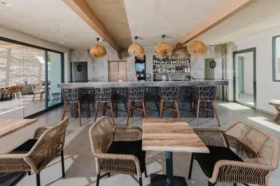 a bar in a room with chairs and tables at Evexia Boutique Hotel & Spa in Agia Marina Nea Kydonias