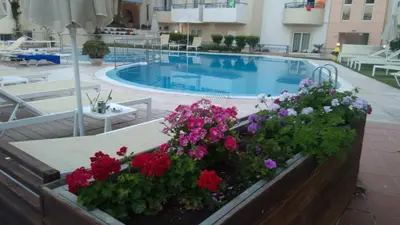 a swimming pool with flowers next to a building at Melina Beach in Plataniás