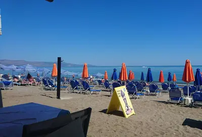 a group of chairs and umbrellas on a beach at Melina Beach in Plataniás