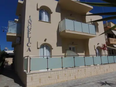 a building with a balcony in front of it at Angelica Studios and Apartments in Agia Marina Nea Kydonias