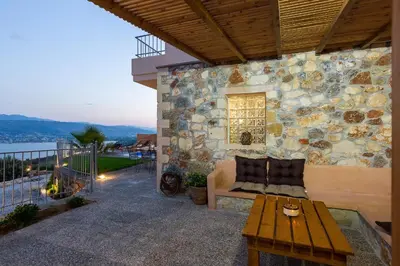 a stone building with a couch and a table on a patio at Istros Villas - with Pools, BBQ & Heated Spa Whirlpools, By ThinkVilla in Korakiaí