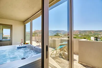 a bathroom with a tub with a view of the mountains at Lydia's Apartments in Kissamos