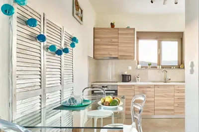 a kitchen with a glass table with a bowl of fruit on it at Lydia's Apartments in Kissamos