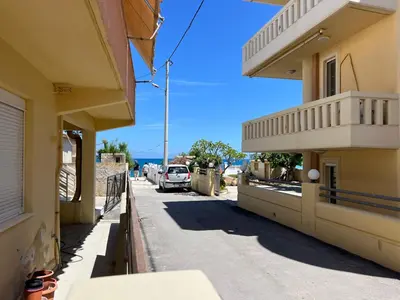 a street with a car parked on the side of a building at Artemis Rooms two steps by the sea in Plataniás
