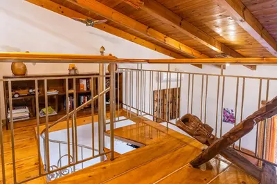 an attic room with a wooden floor and a wooden table at Olive Villas in Kría Vrísi