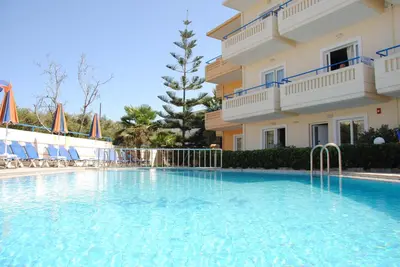 a swimming pool in front of a building at Dias Hotel Apartments in Agia Marina Nea Kydonias
