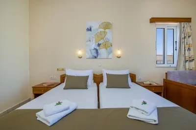 a bedroom with a large white bed with towels on it at Dias Hotel Apartments in Agia Marina Nea Kydonias