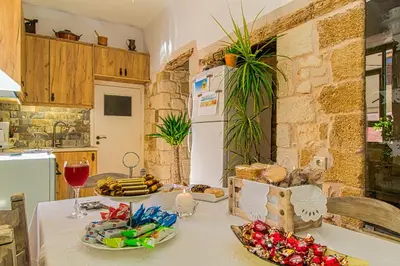 a kitchen with a table with food and wine glasses at Antonia Traditional Estate in Chania Town