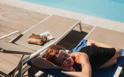 a woman laying on a chair next to a table at Royal Sun in Chania Town