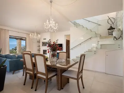 a dining room and living room with a table and chairs at Villa Aloni in Kissamos