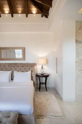 a white bedroom with a bed and a table at Villa Aloni in Kissamos