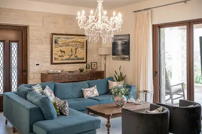 a living room with a blue couch and a table at Villa Aloni in Kissamos